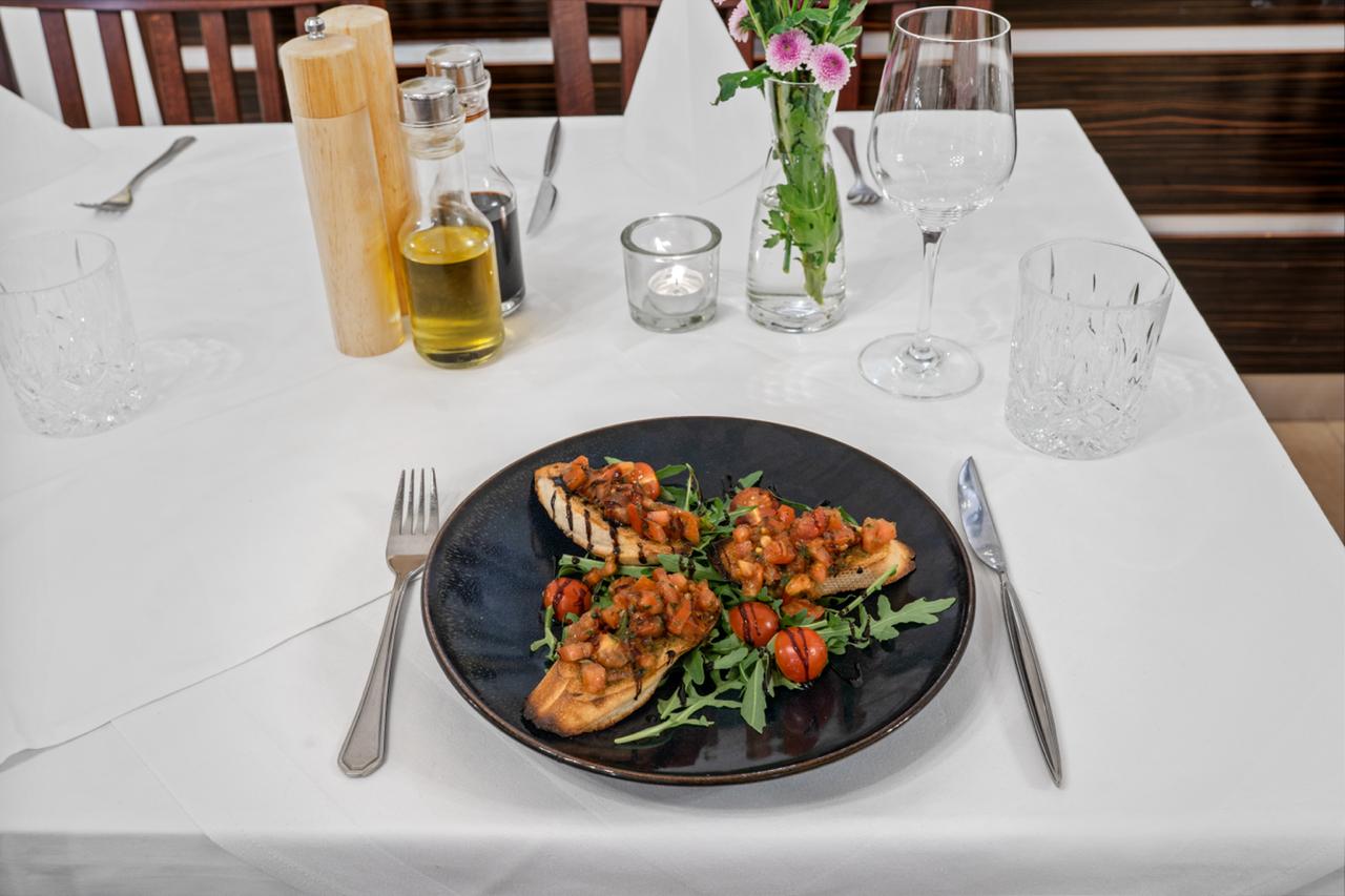 Bruschetta auf schwarzem Teller — original Antipasti im Restaurant Volare