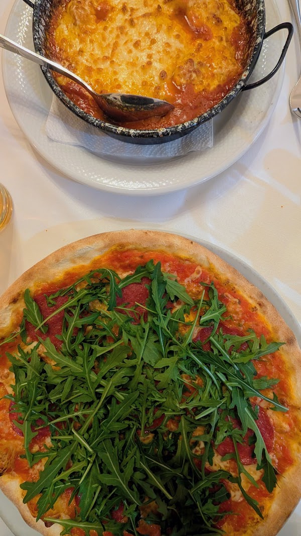 Pizza mit frischer Rucola und Lasagne aus dem Steinofen im Volare