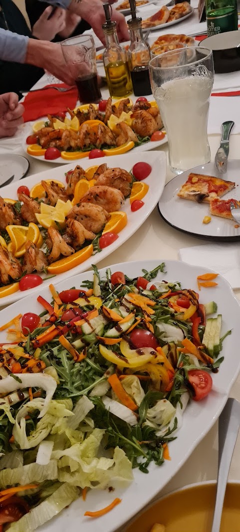 Gedeckter Tisch im Volare mit Antipasti, Salaten und gegrillten Garnelen für die Tafelrunde